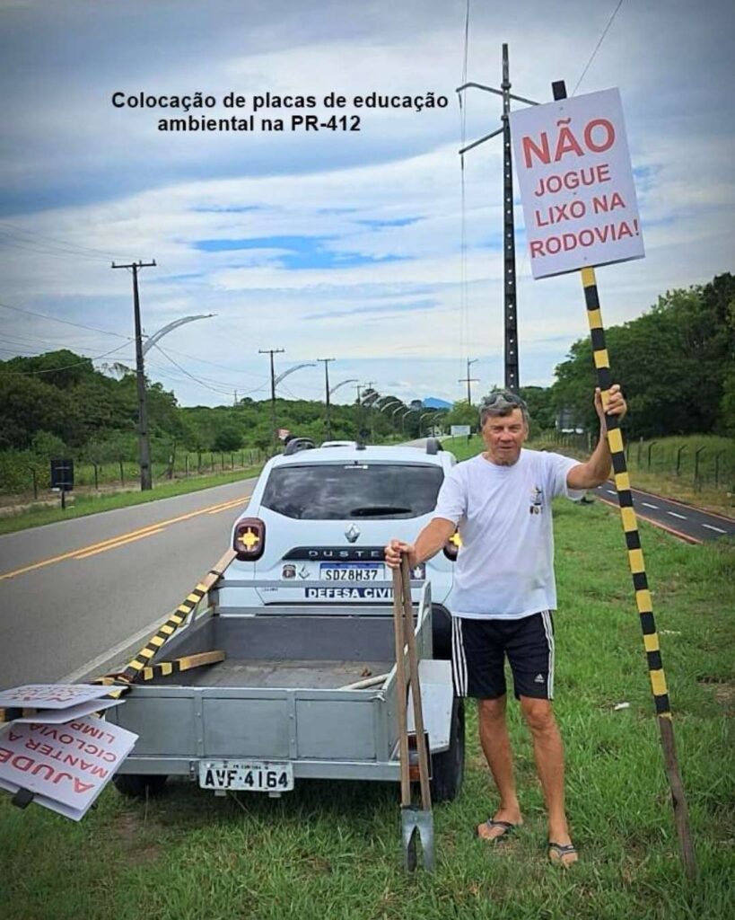 João Carlos Lima segura uma placa educativa durante a ação de Limpeza ciclovia PR-412 em Pontal do Paraná.